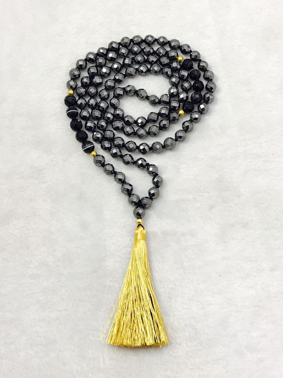 Original Yantrakart dark faceted mala with a golden tassel